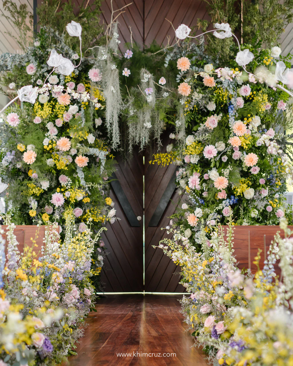 A whimsical forest-inspired archway design welcoming a spring-inspired wedding ceremony