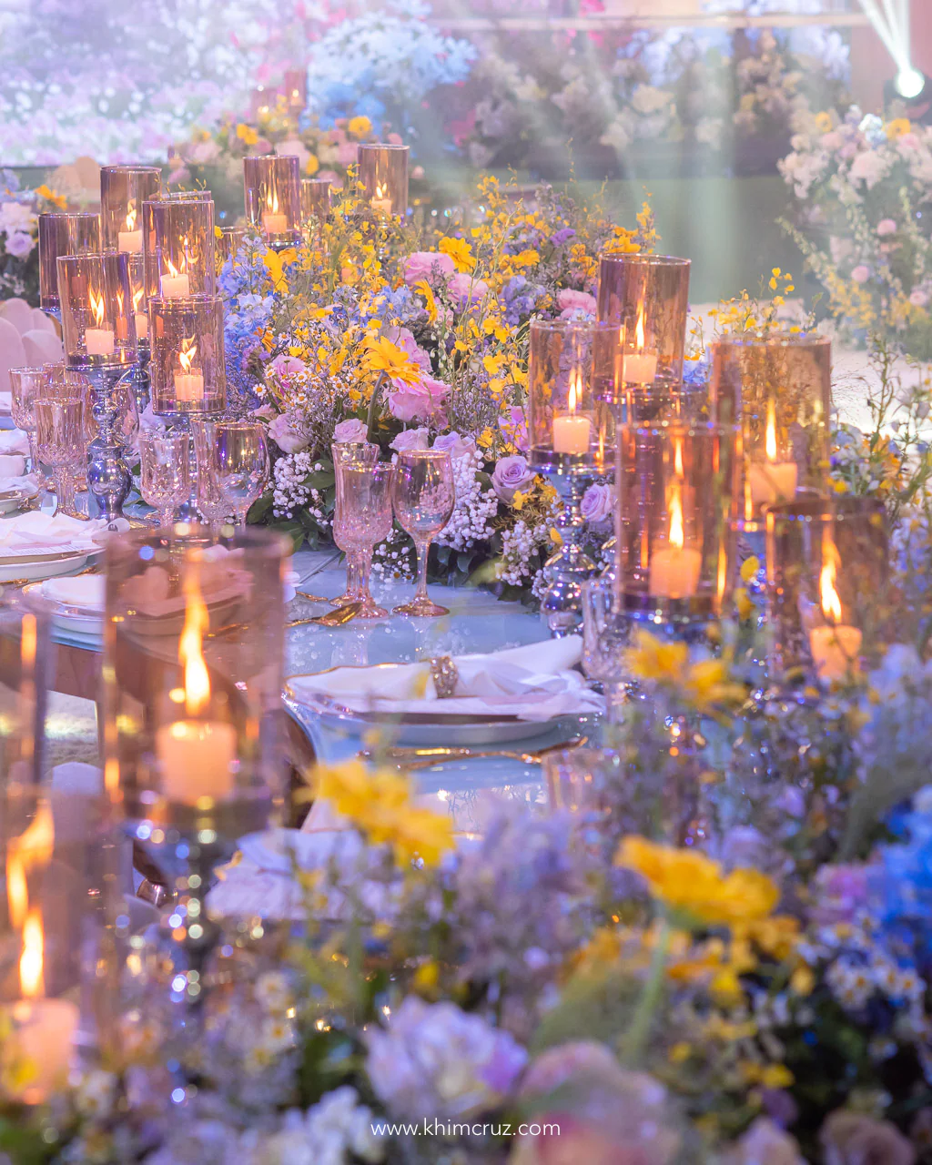 Candlelit ambiance and romantic floral arrangements create a dreamy spring garden-themed wedding table setup