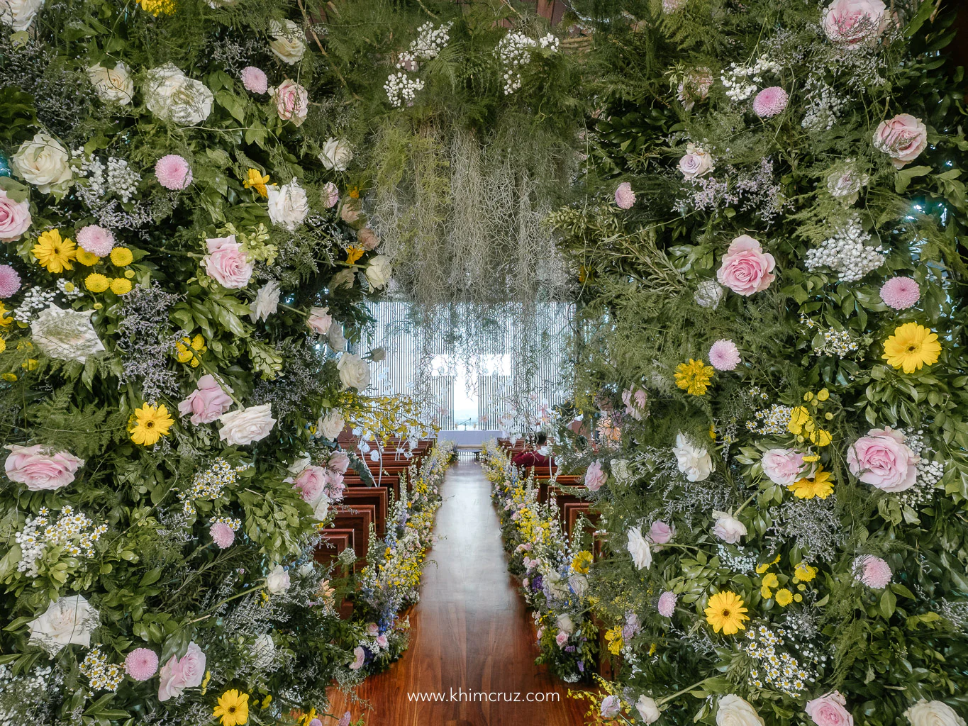 Floral archway guiding the path to a spring-themed wedding ceremony