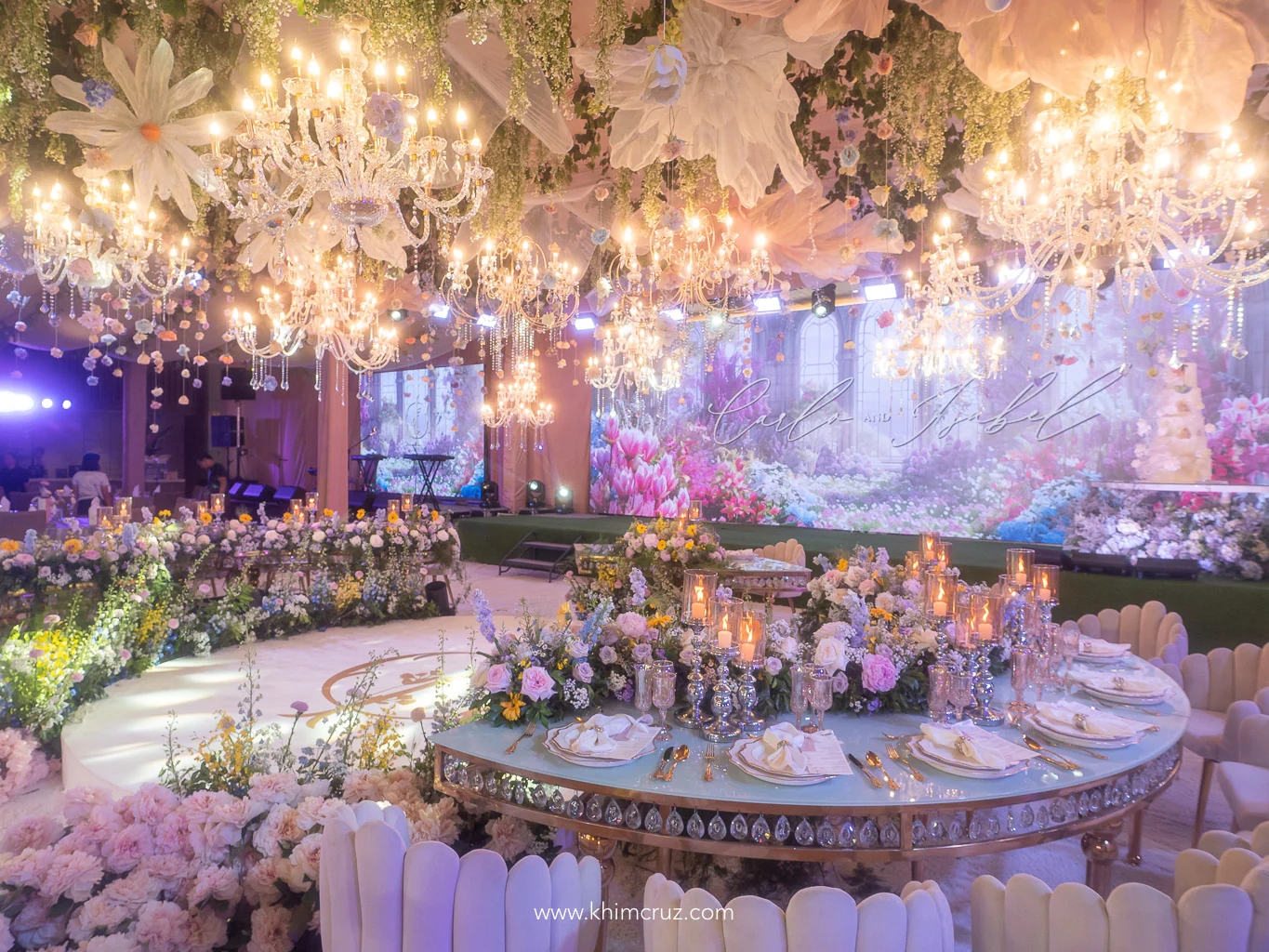 a dreamy spring garden wedding reception featuring elegant table settings lush floral centerpieces chandeliers and stunning ceiling floral designs