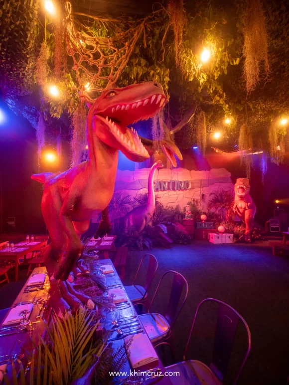 Velociraptors playfully perch on the tables on dinosaur themed 1st birthday party