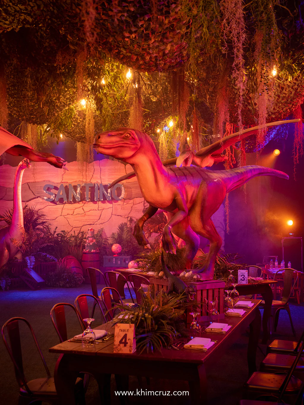 Velociraptors stand on the tables of dinosaur-themed celebration