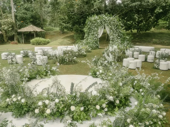 a bespoke wedding ceremony with lush white florals and elegant unstructured floral arch entrance