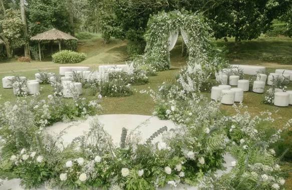 a bespoke wedding ceremony with lush white florals and elegant unstructured floral arch entrance