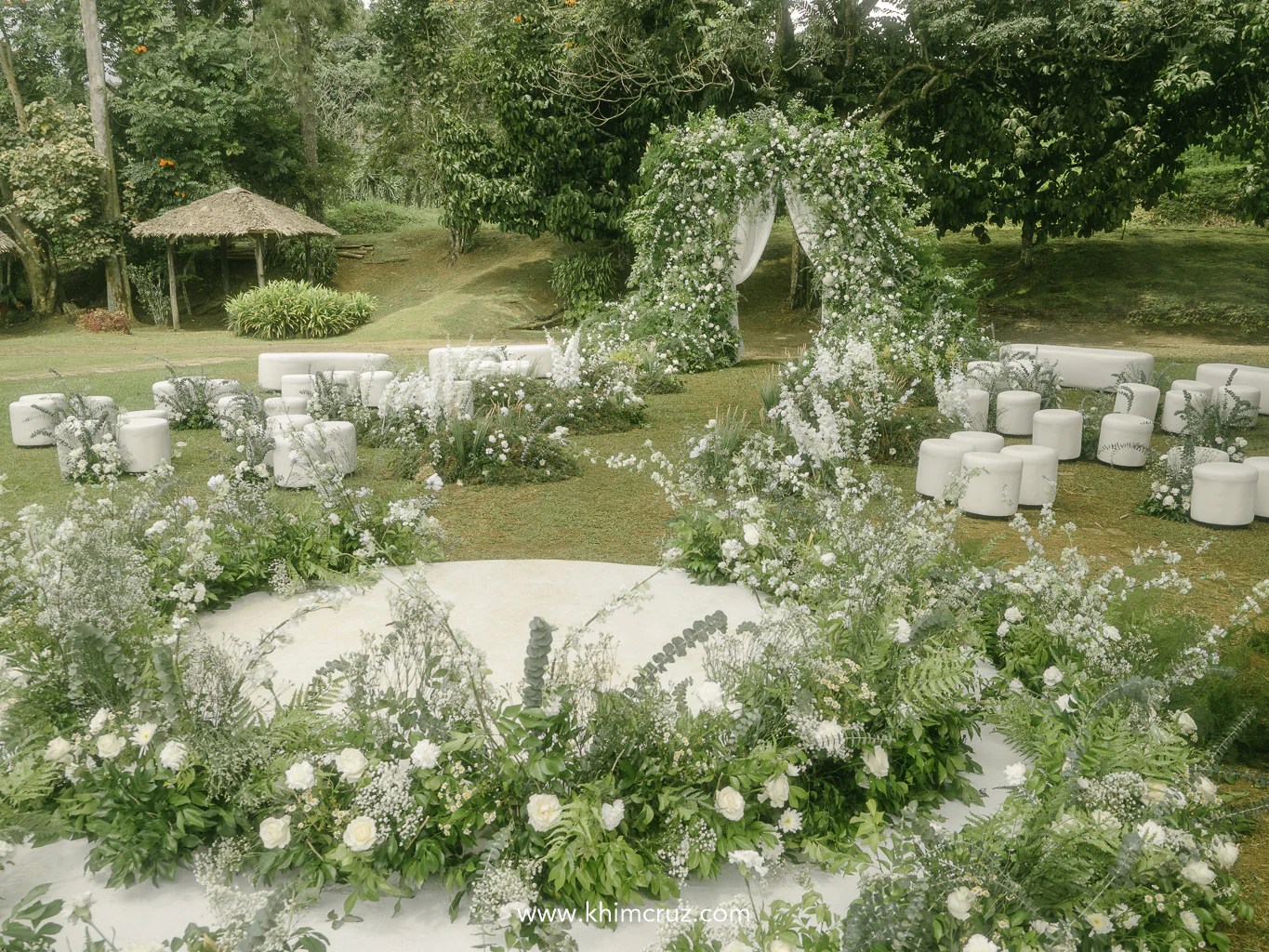 a bespoke wedding ceremony with lush white florals and elegant unstructured floral arch entrance