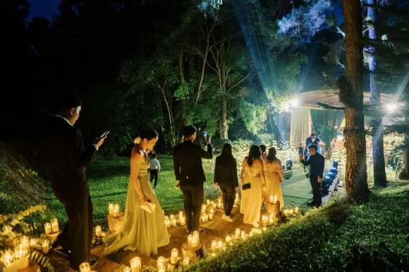 glowing staircase lined with candles guides the way to a field of white blooms