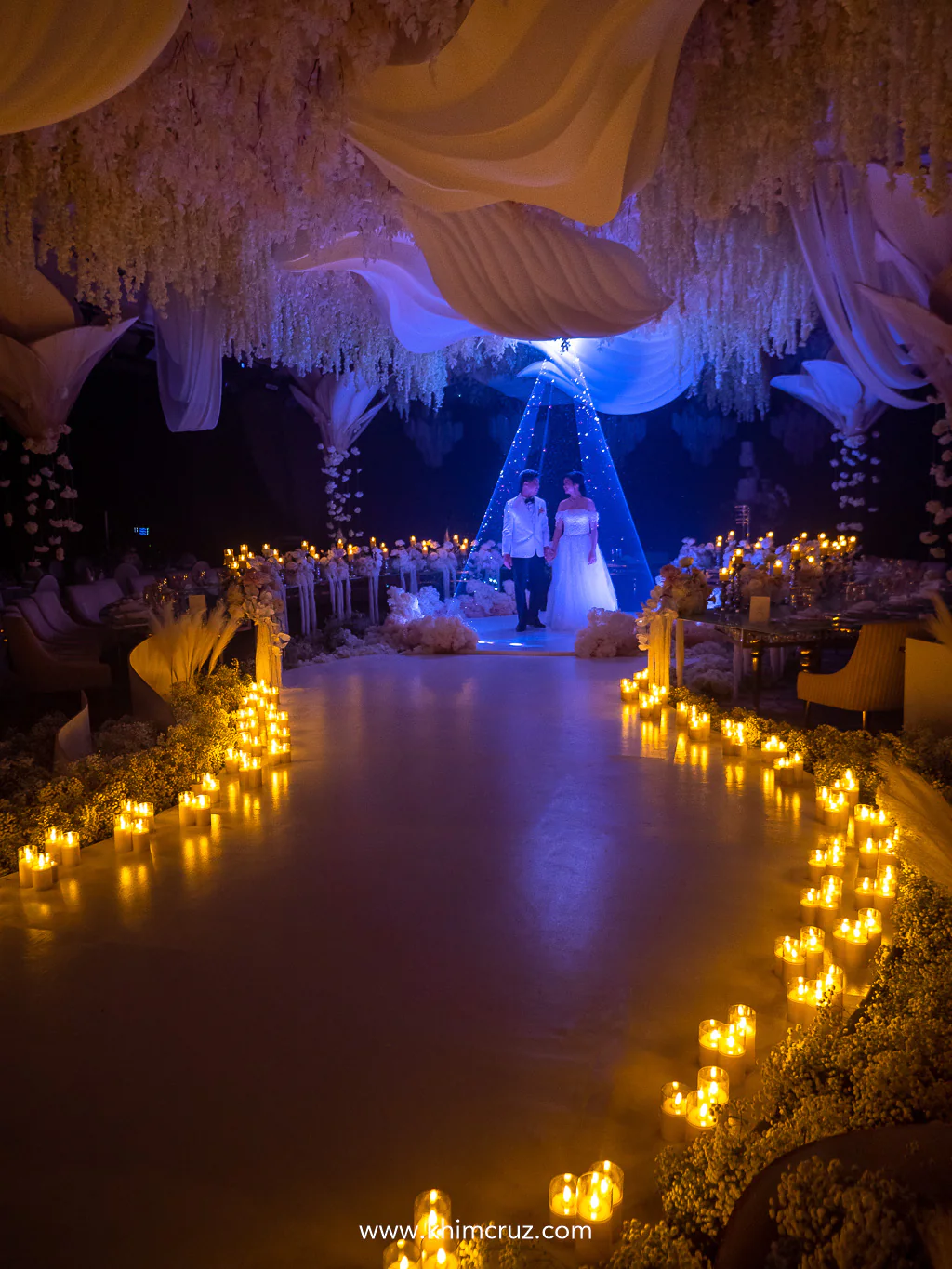 Candlelight illuminates the pathway to the dance floor setting a romantic glow for the wedding