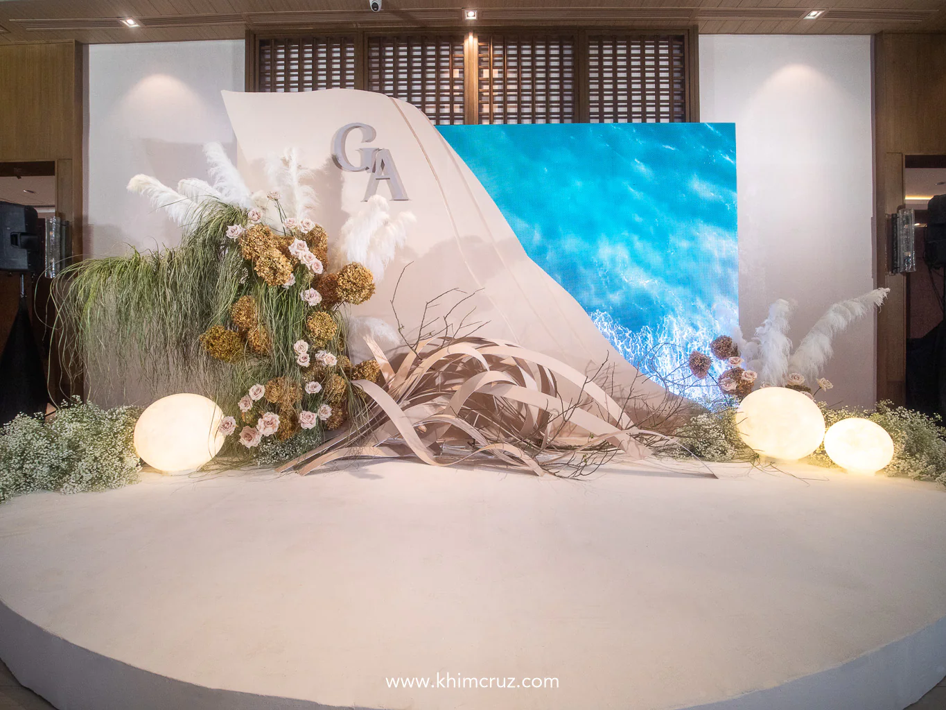 a seashore-themed photo wall backdrop combines floral art with moving display