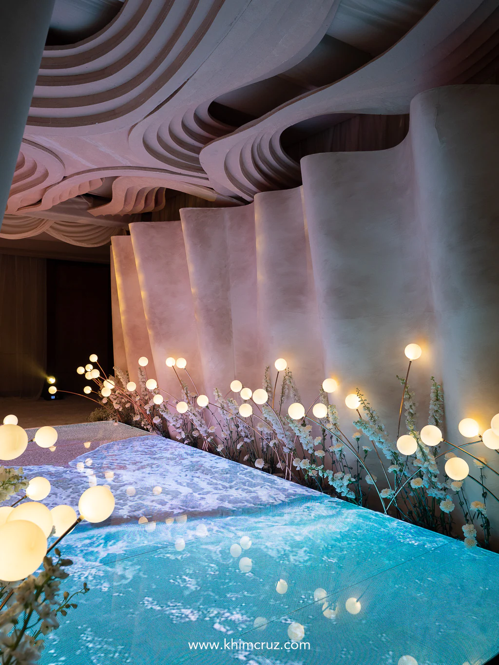 a wedding entrance tunnel that evokes rhythm of ocean waves with floor display bringing motion of waves