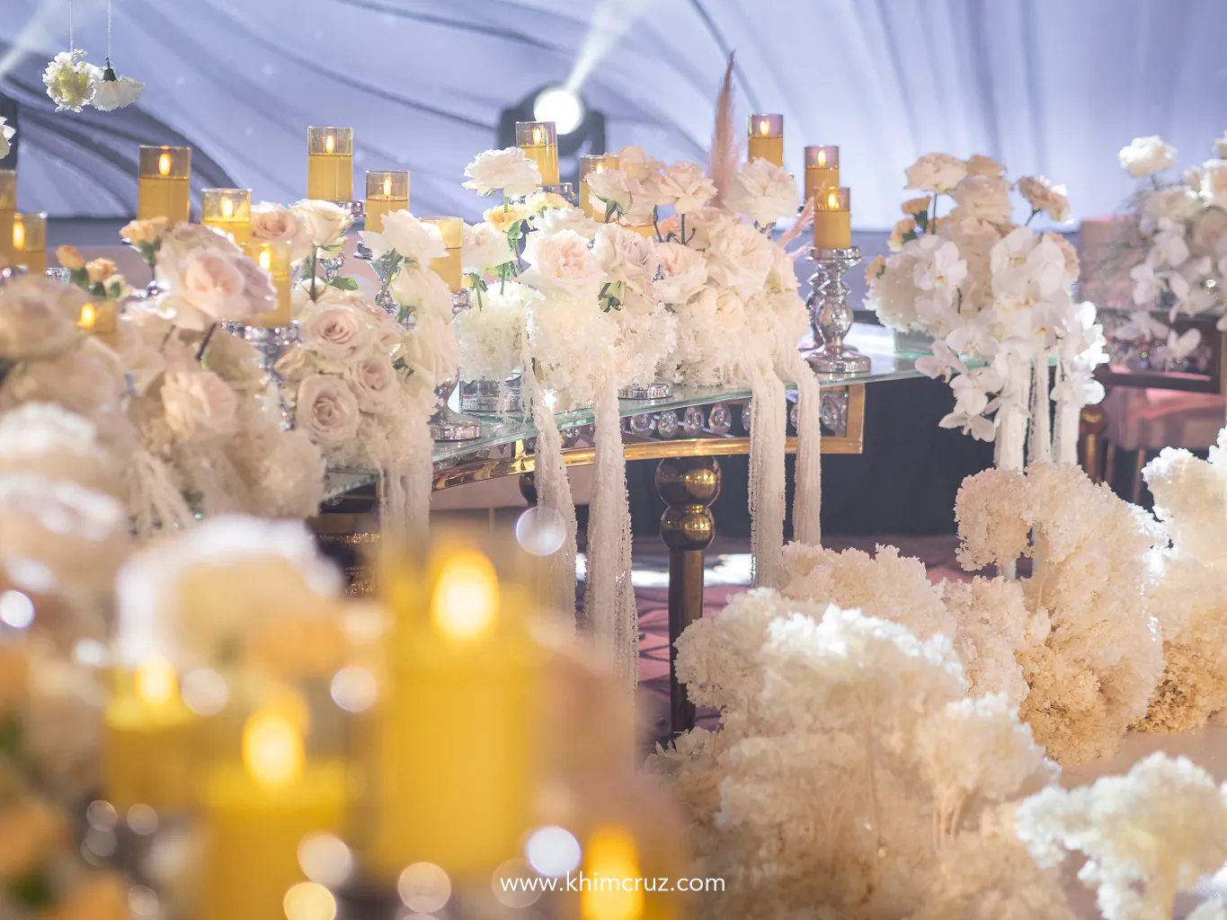 cascading flowers on a wedding table with roses and candles