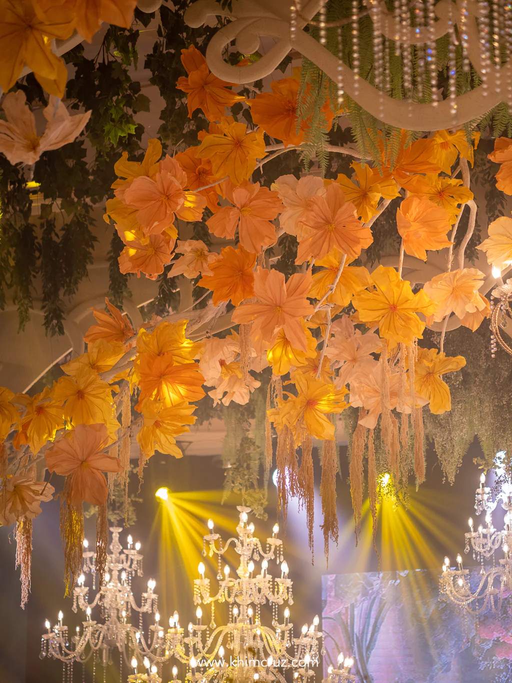 crafted orange blooms illuminated by warm glow of chandeliers on the Art Nouveau-infused wedding