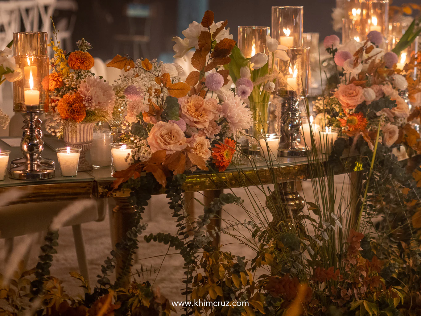 tables adorned by mix of pastel and warm-toned florals and potted blooms