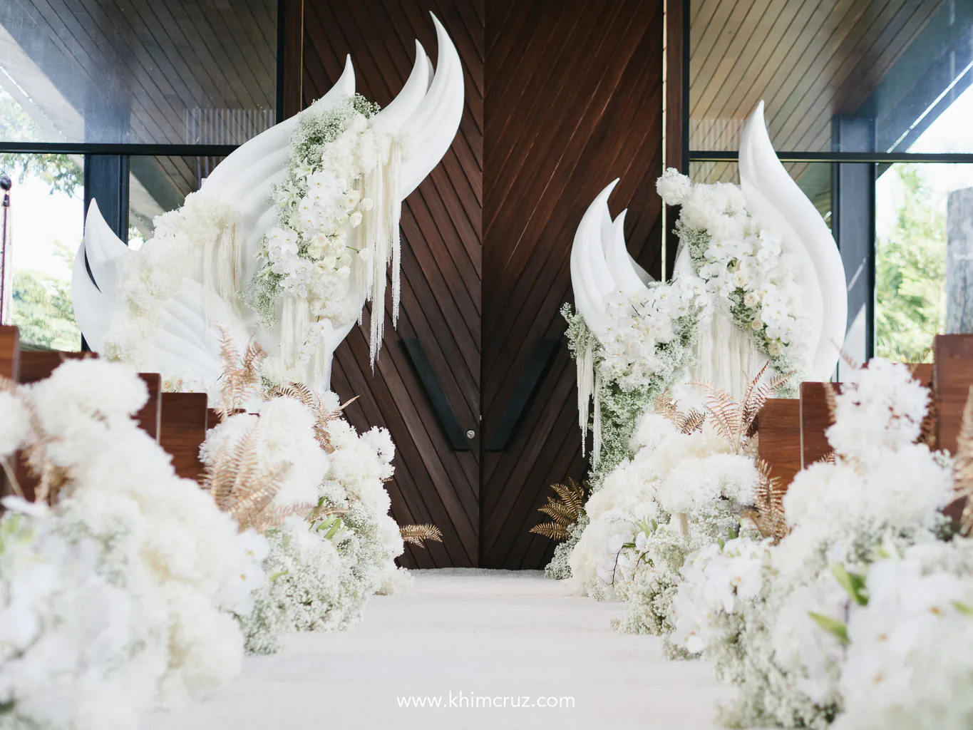 a reimagined traditional arch floristry with an unconventional twist incorporating a breathtaking structure adorned with lush white florals