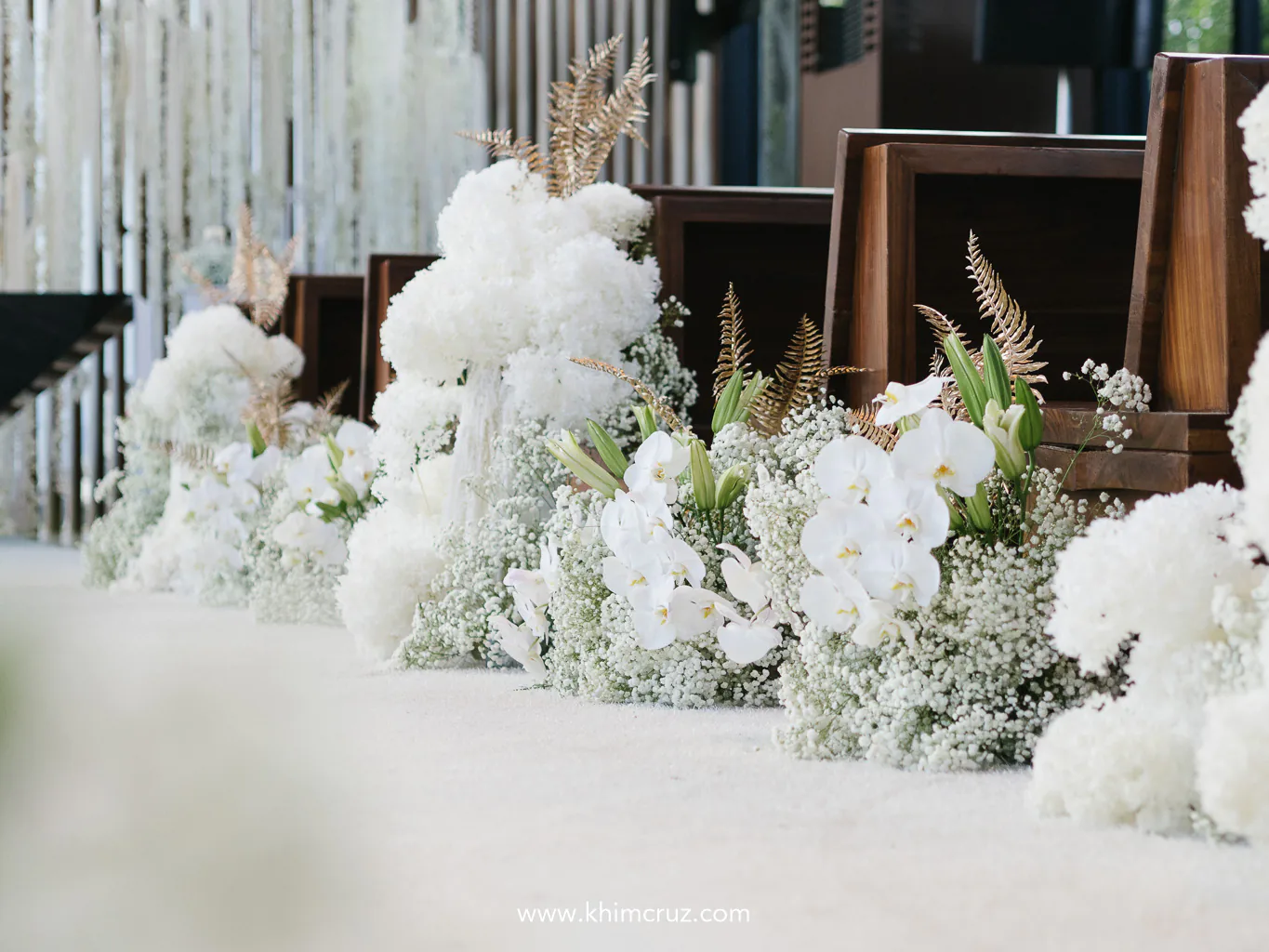 a wedding aisle with cascading white blooms