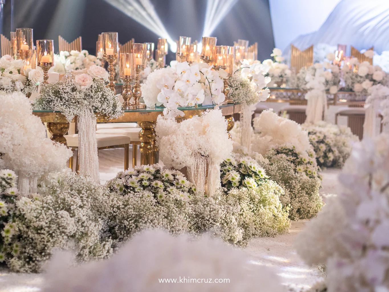 delicate white florals and the soft flicker of candlelight create a dreamy ethereal ambiance for the elegant wedding