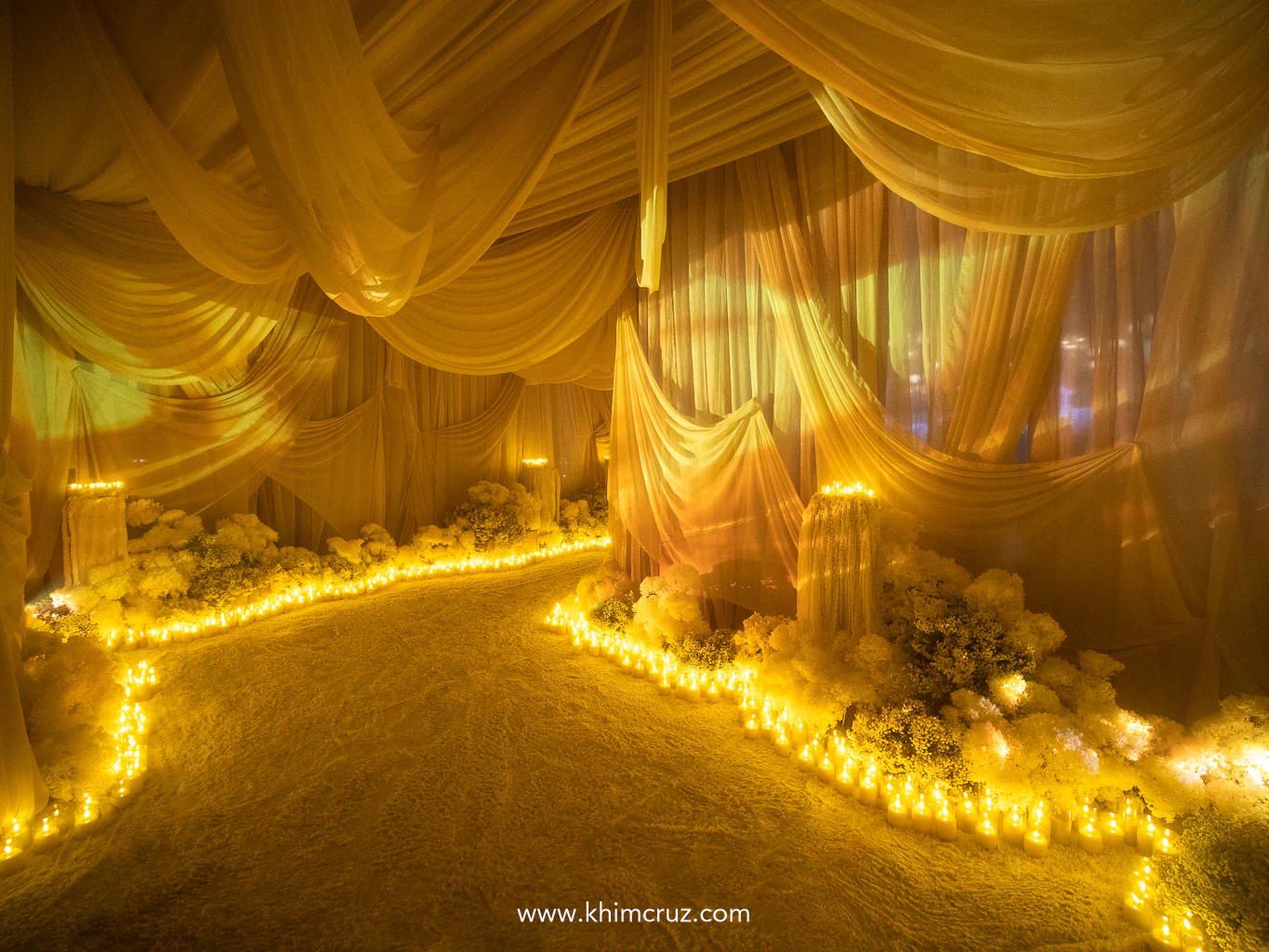 this wedding's entrance tunnel walls feature elegant draping enhanced by projections of dreamy textures